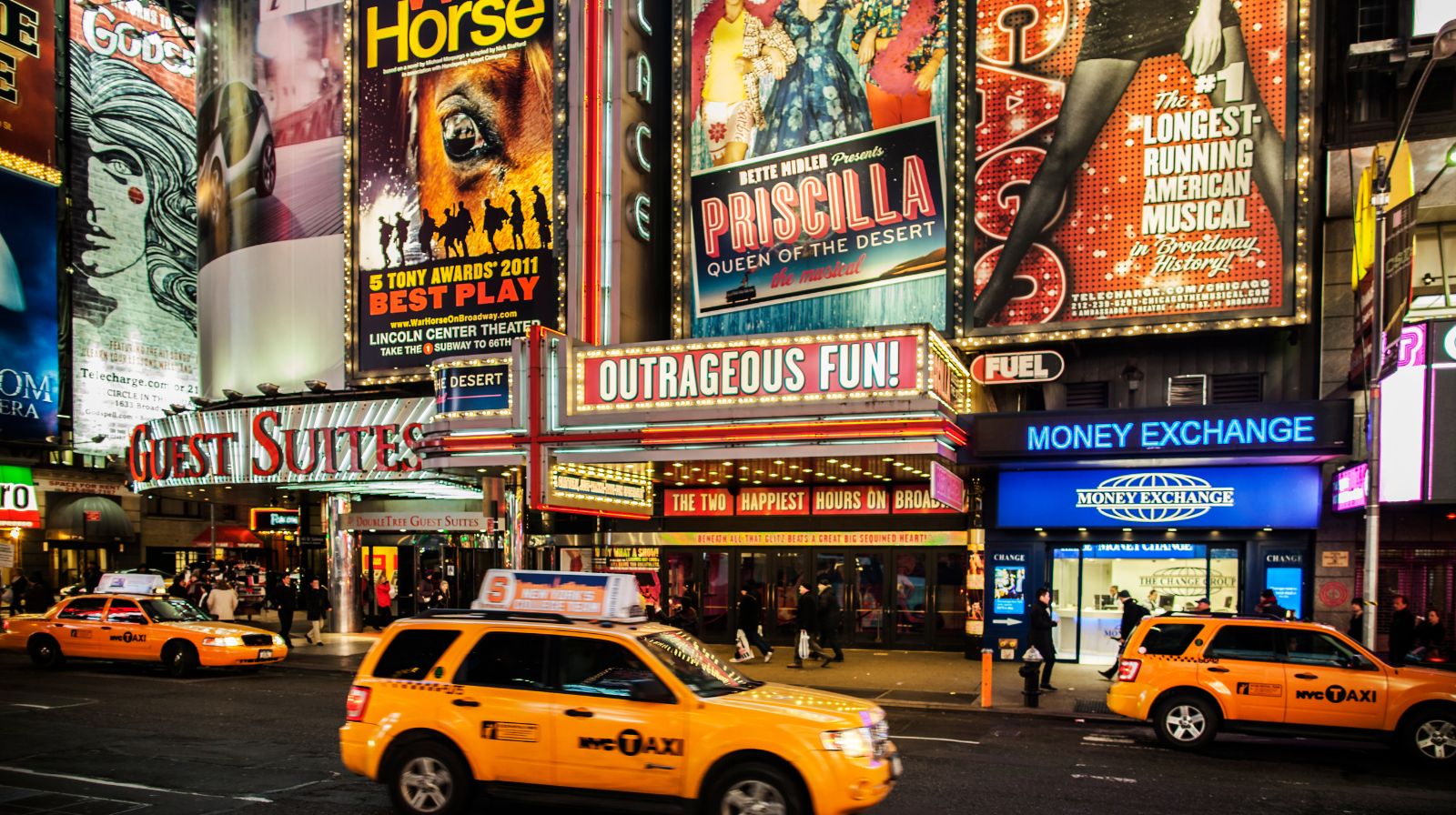 Theaterdistrict van Broadway in New York met neonreclames en drukke straten.