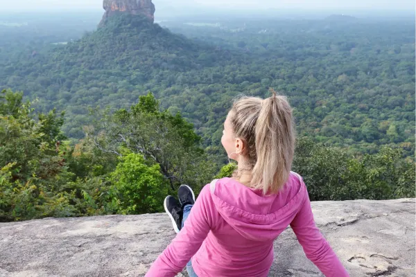 Reiziger kijkt uit over het groene landschap met Sigiriya Rock in Sri Lanka