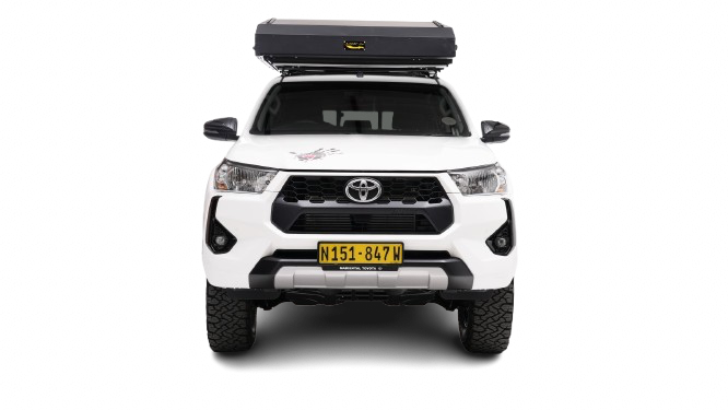 Toyota Hilux Comfort Double Cab automaat met daktent op gravelroad in Namibië, ideaal voor selfdrive reizen.