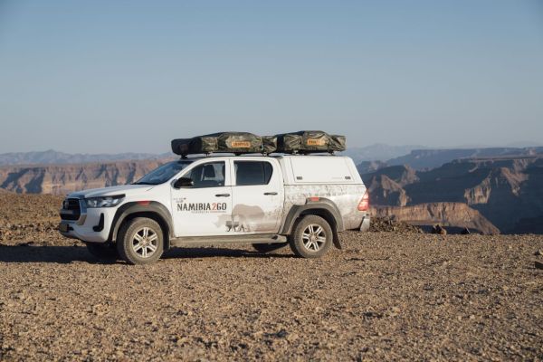 4x4 Toyota Hilux Double Cab Budget met daktent bij campsite in Botswana.