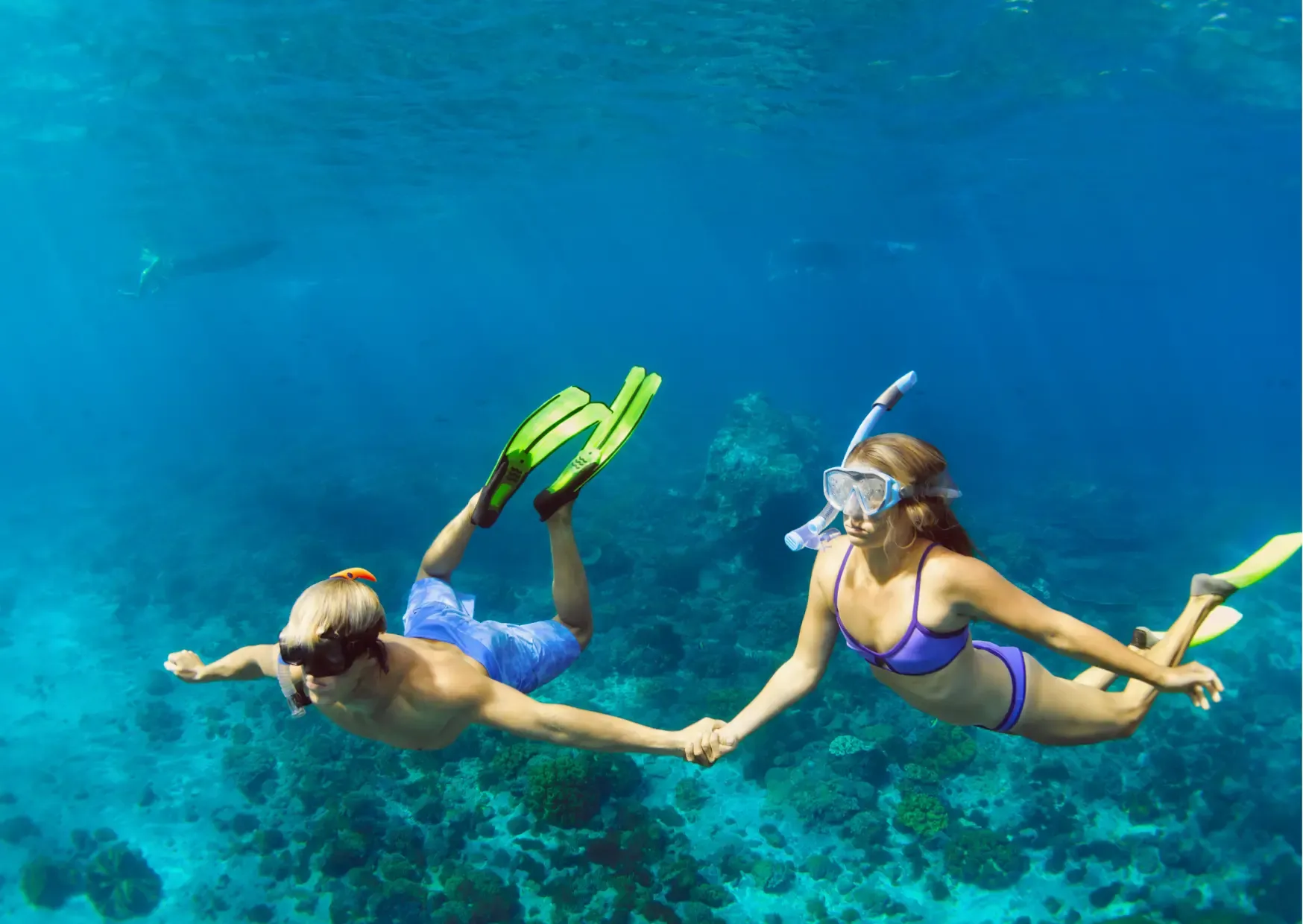 Twee reizigers snorkelen boven het kleurrijke onderwaterleven bij Pulau Giam