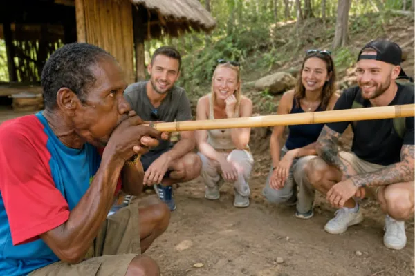 Orang Asli-bewoner geeft een demonstratie met een traditionele blaaspijp aan reizigers