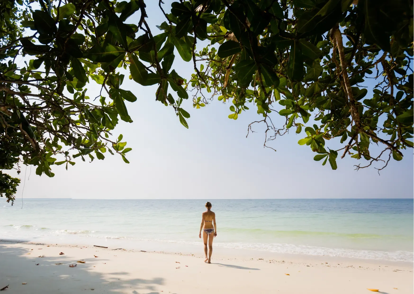 Rustig tropisch strand omgeven door groene natuur op het eiland Pangkor