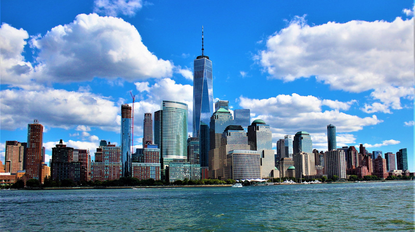 Skyline van New York overdag met wolkenkrabbers en helderblauwe lucht.