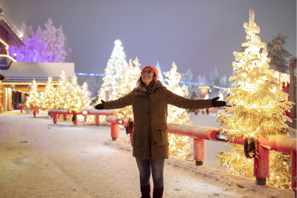 Sfeervol Santa Claus Village in de avond met verlichting en sneeuw in Lapland