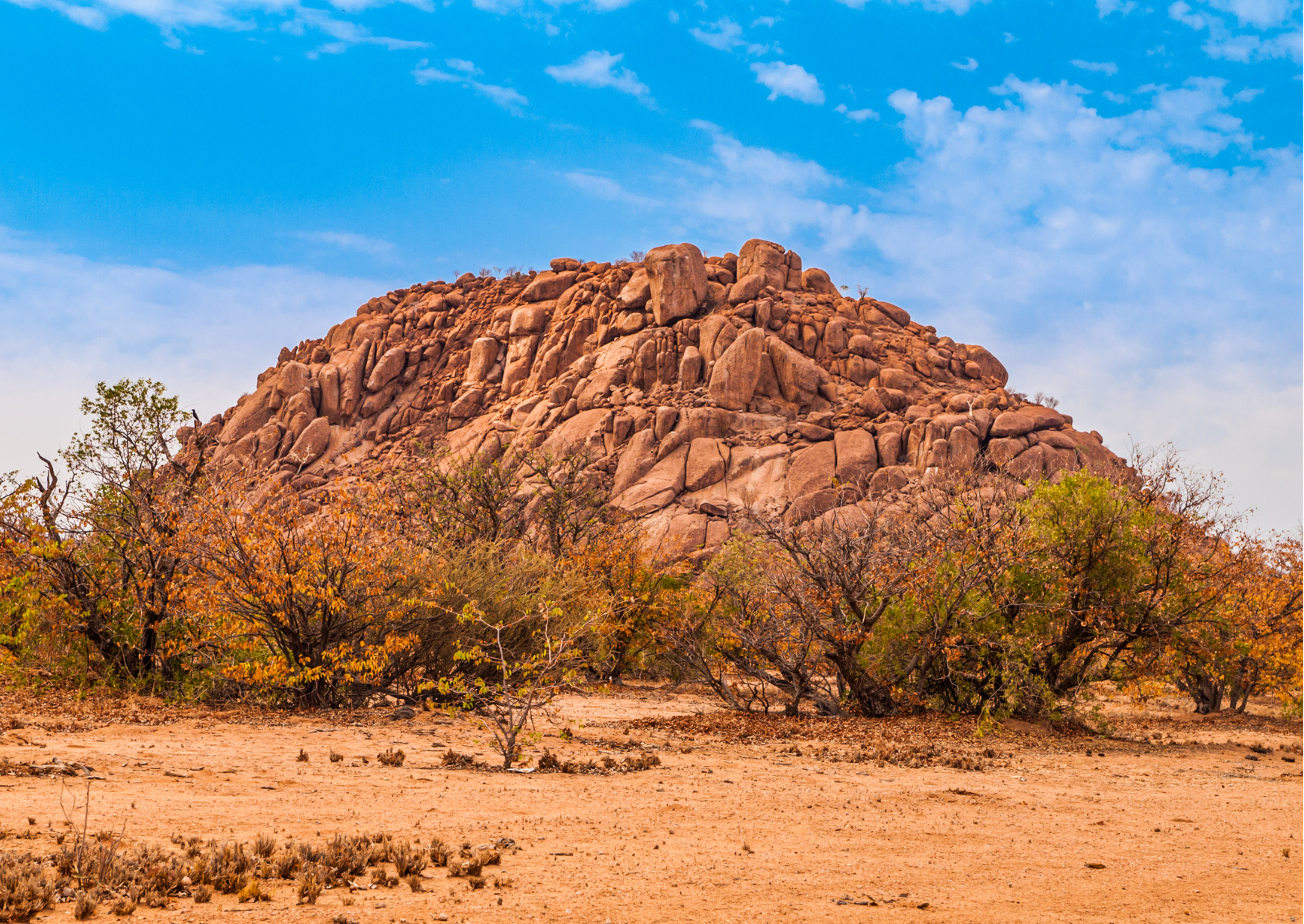 “Indrukwekkende oranje rotsformaties in Damaraland, een van de meest ongerepte en fotogenieke regio’s van Namibië.”