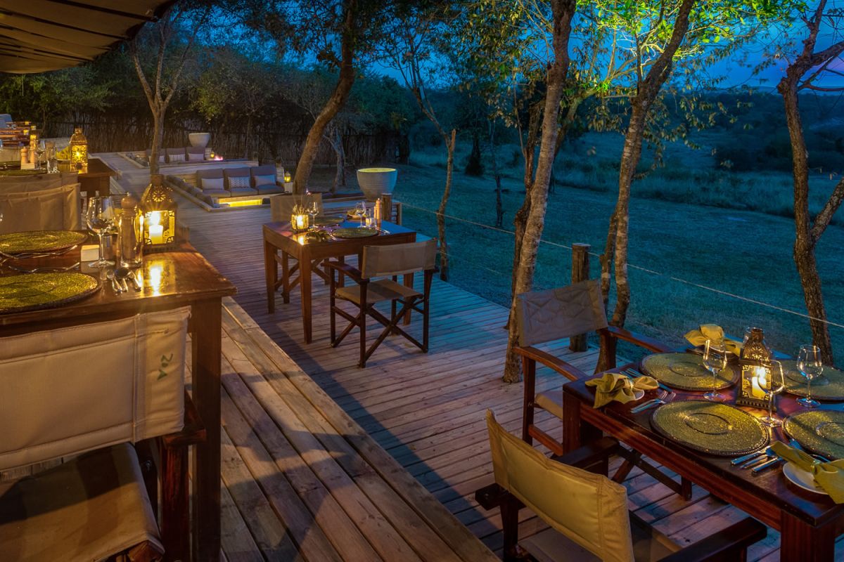 Sfeervolle bush-diner setting bij Entim Mara Luxury Camp onder Afrikaanse sterrenhemel