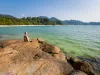 16-daagse rondreis Maleisië met Taman Negara en Pangkor Reiziger op rotsen aan zee met een groen strand en beboste heuvels