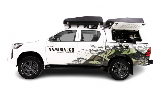 4x4 Toyota Hilux Comfort Double Cab met daktent geparkeerd bij campsite in Botswana.