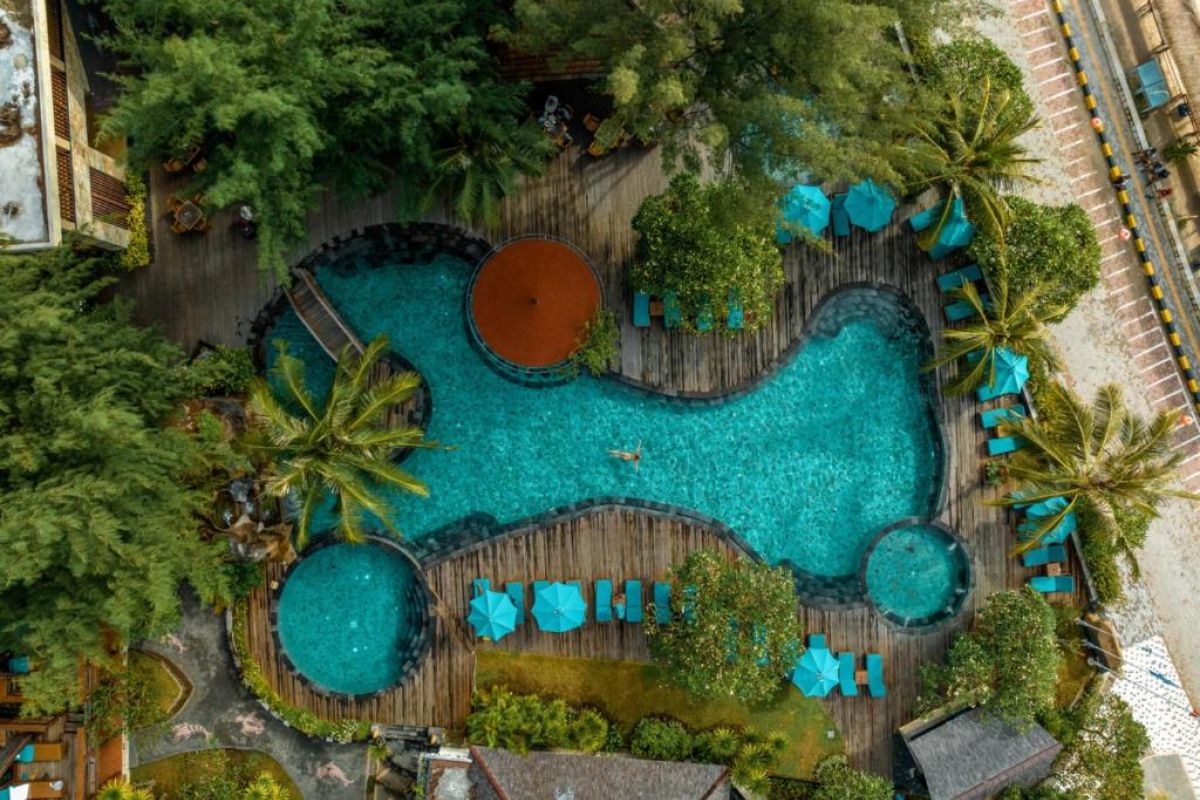 “Tropisch zwembad van Vila Ombak Gili Trawangan omringd door palmbomen.”