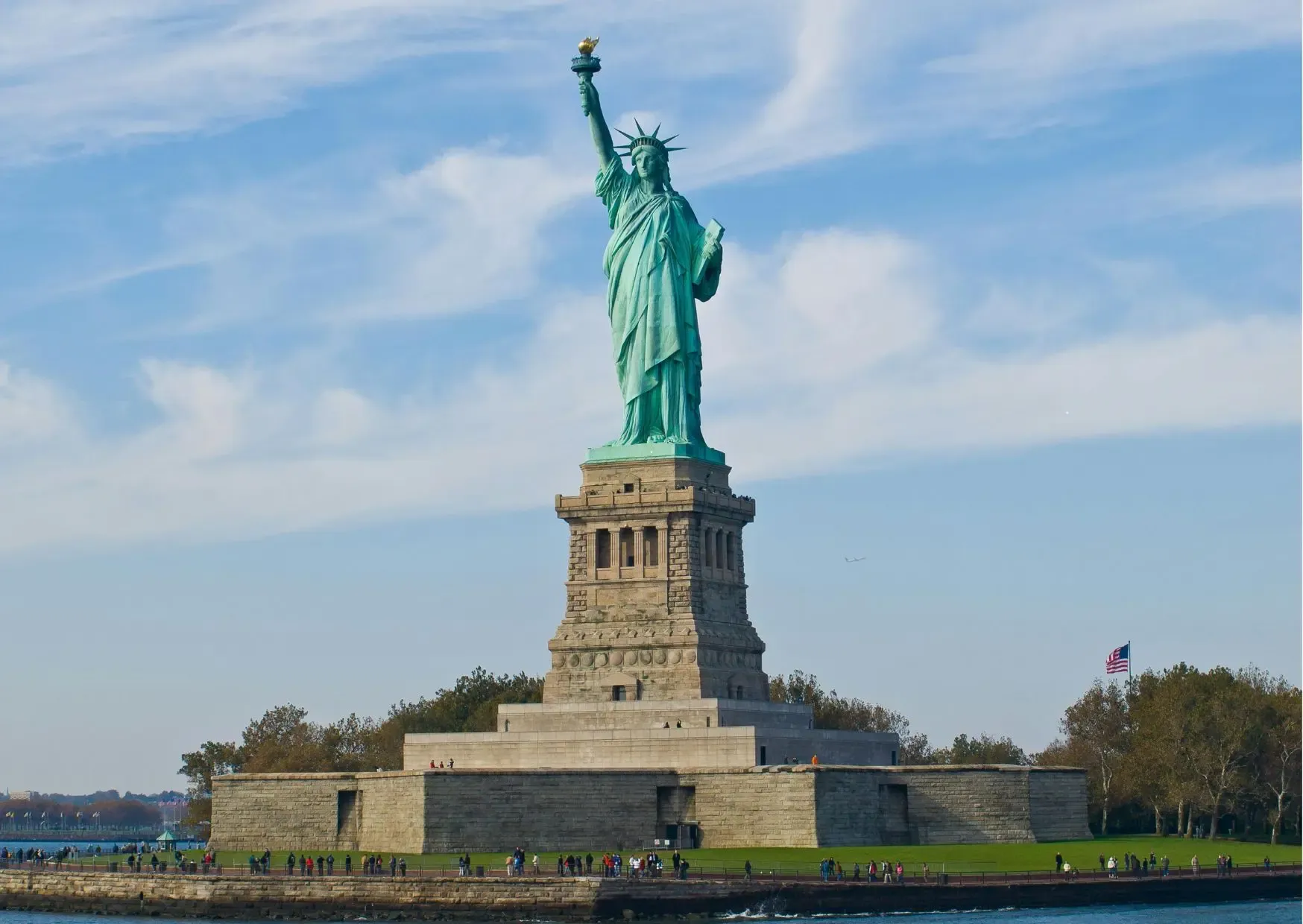 Het Vrijheidsbeeld op Liberty Island in de haven van New York onder een blauwe lucht