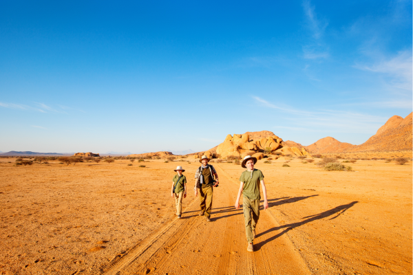 Reiziger met hoed en waterfles in het warme woestijnklimaat van Namibië