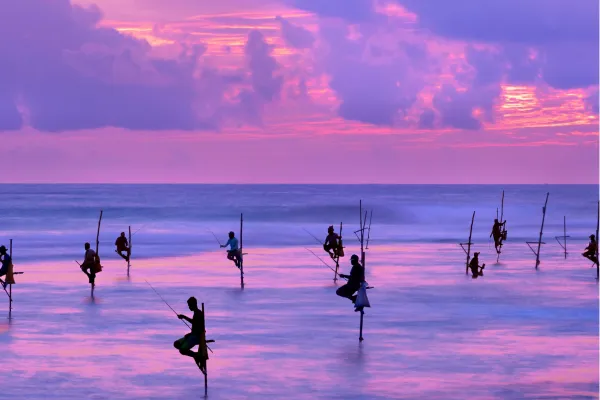 Traditionele steltvissers in zee aan de zuidkust van Sri Lanka