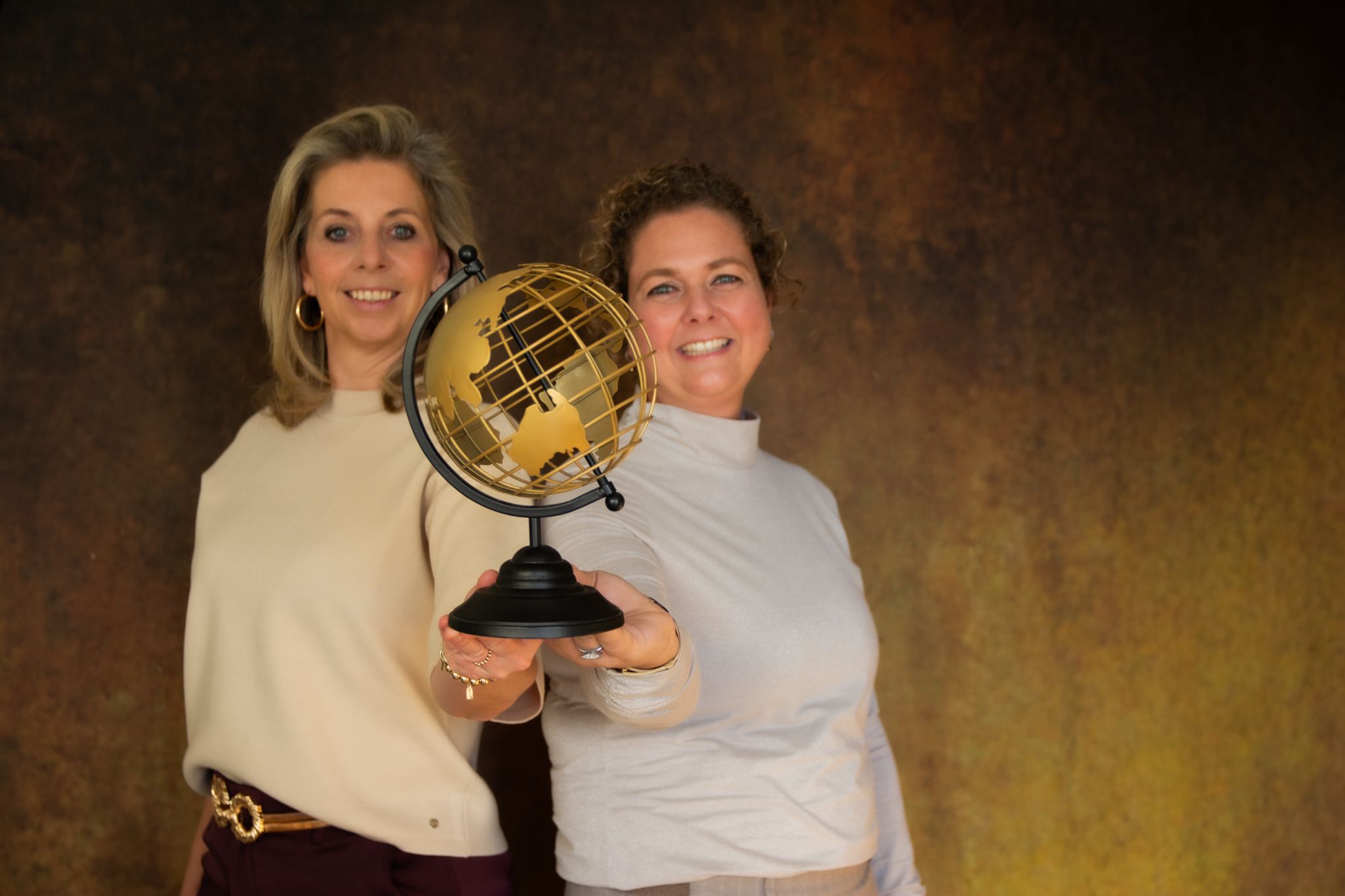 MyGlobe2Go, twee reisadviseurs met een gouden wereldbol, symbool voor maatwerkreizen en persoonlijke reisplanning naar bestemmingen wereldwijd.