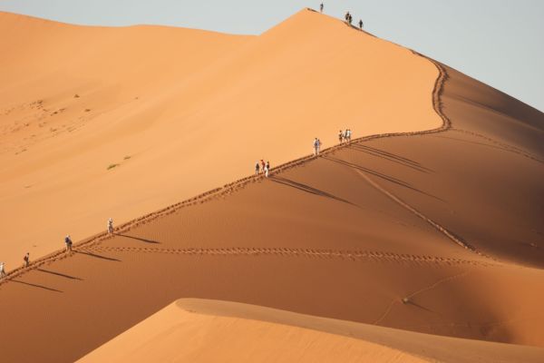 “Beklimmen van de rode zandduinen in Sossusvlei in Namibië, een iconische woestijnervaring in de Namib-woestijn.”