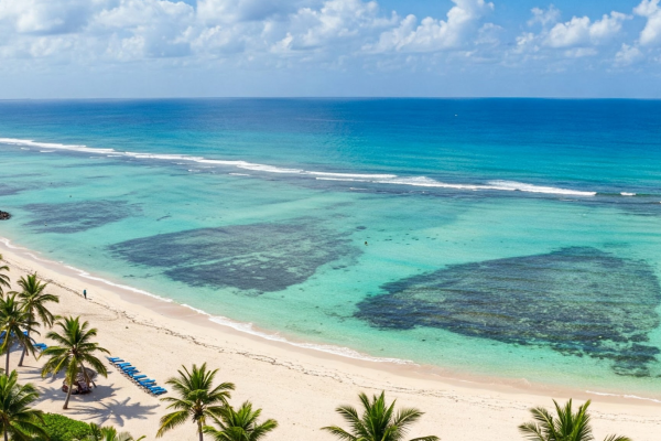 Wit zandstrand bij Eleven Pearl Diani met turquoise zee, rustige sfeer en luxe boutique-ervaring aan de Indische Oceaan.