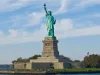 13-daagse droomreis New York & Caribbean Cruise Het Vrijheidsbeeld op Liberty Island in de haven van New York onder een blauwe lucht