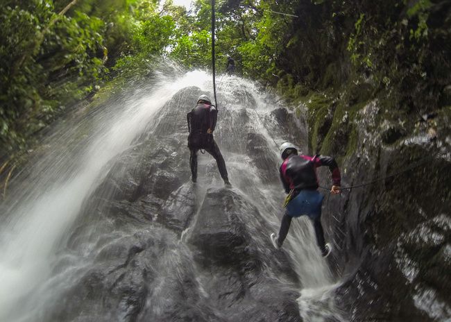 Canyoning in Río Blanco bij Baños, waarbij je langs watervallen en rotsen afdaalt midden in het tropische Andeslandschap.