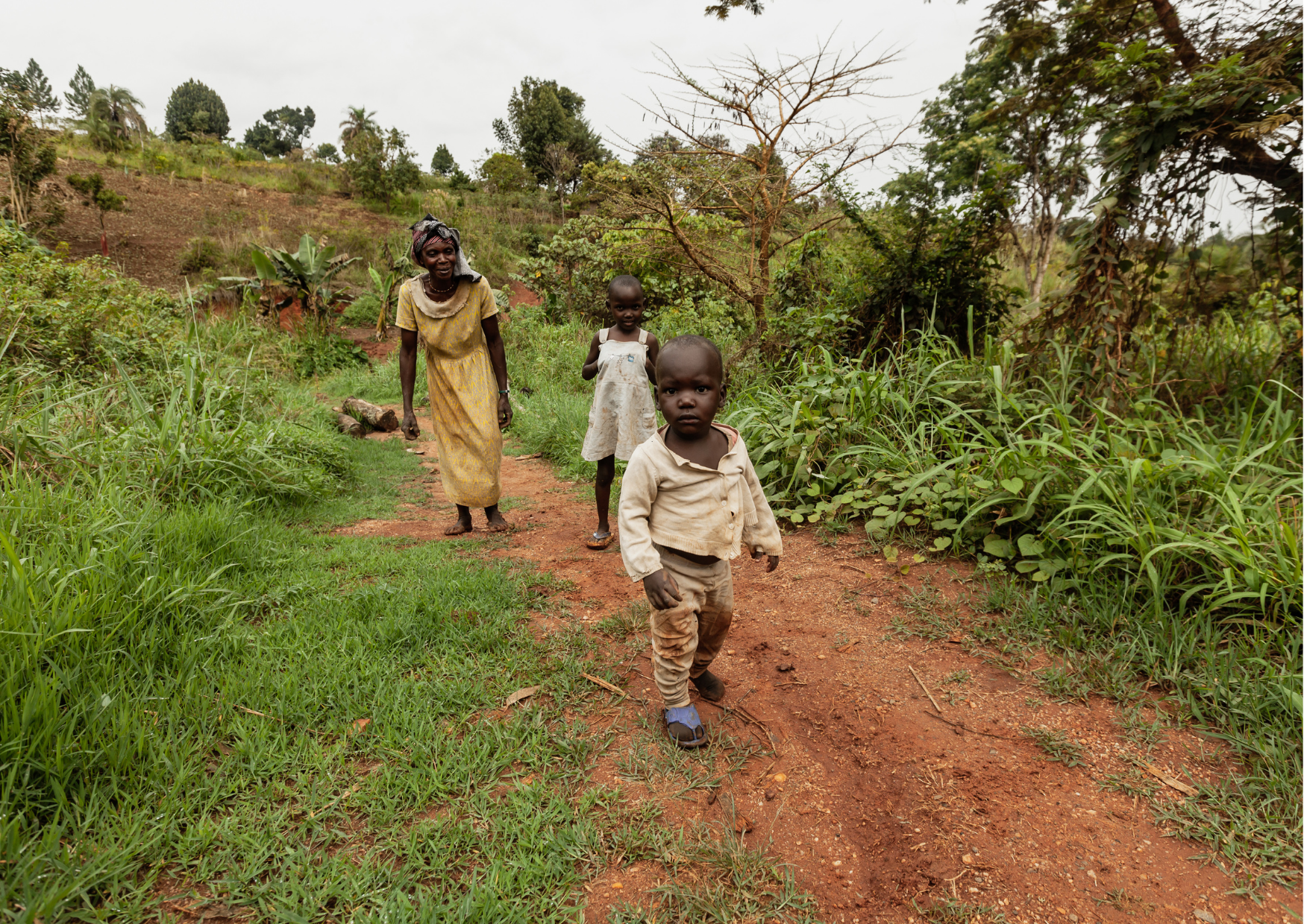 “Een alledaags tafereel van kinderen die over een zandpad langs de weg lopen, een kijkje in het lokale leven.”