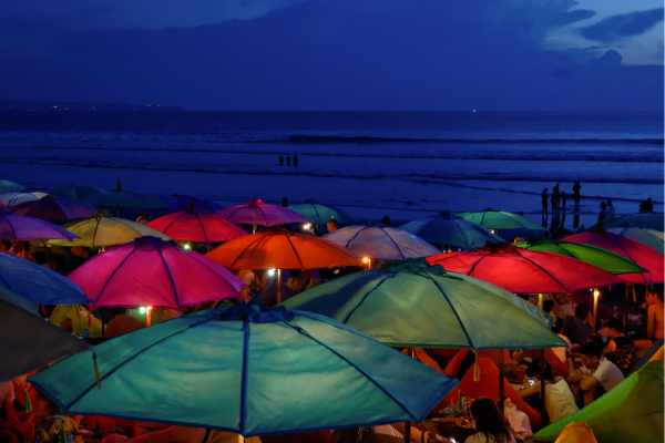 Seminyak beachclub bij avond met gekleurde paracols