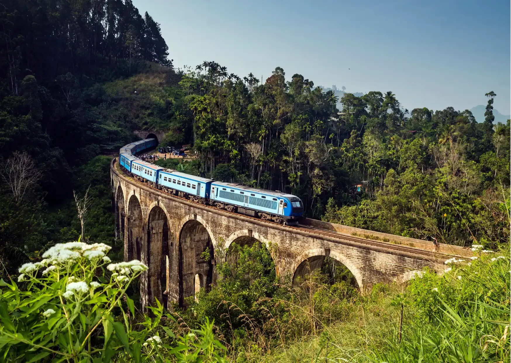 Blauwe trein rijdt door het groene berglandschap bij Ella in Sri Lanka