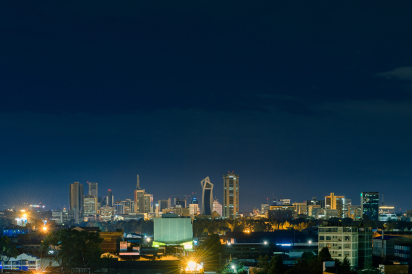 Verlichte-skyline-van-Nairobi-tijdens-schemering-met-hoogbouw-op-de-achtergrond.