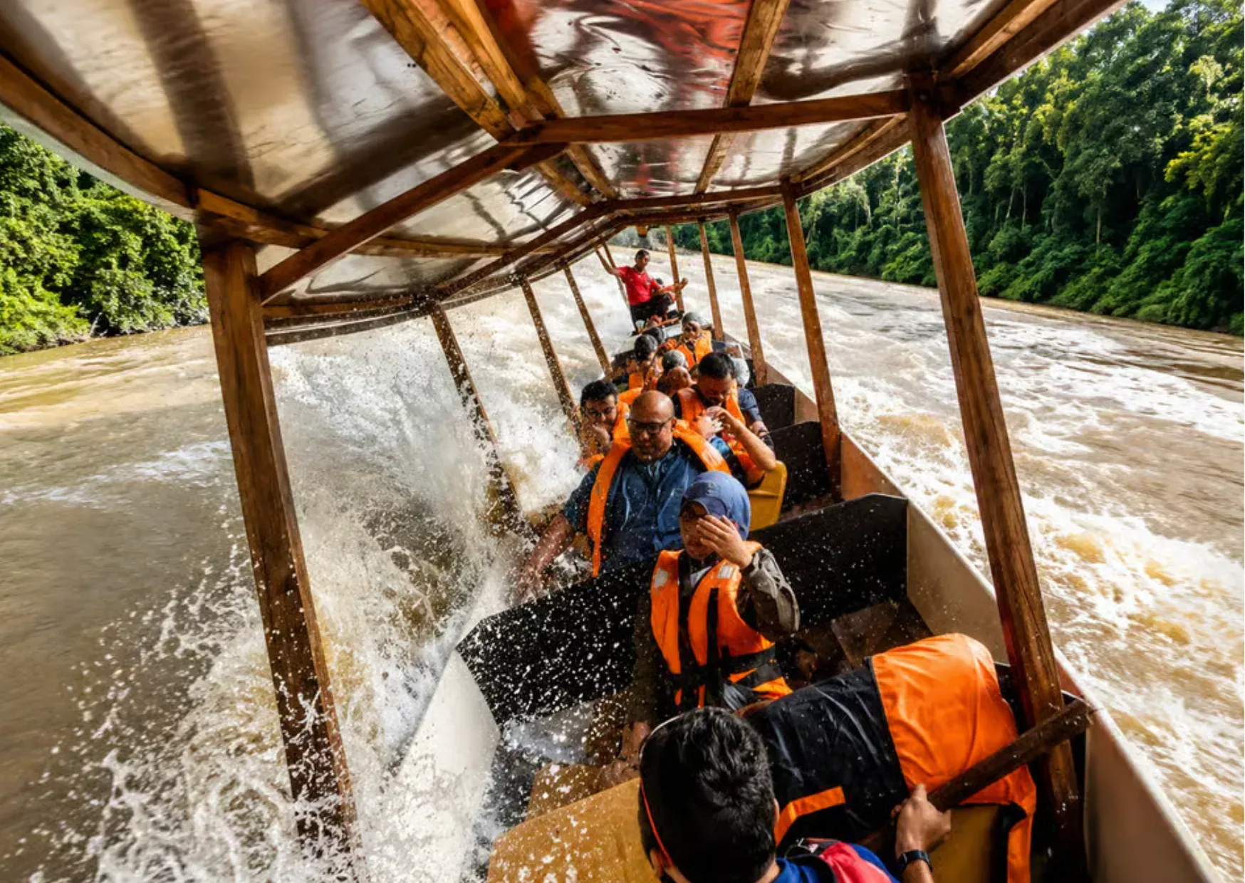 Reizigers tijdens Rapids Shooting met een houten boot op de Tembeling-rivier