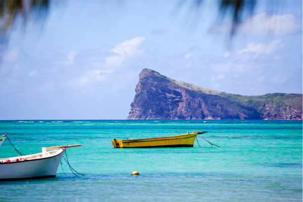 Mauritius Strand met berg en bootjes