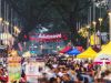 Drukke streetfoodmarkt met kleurrijke kraampjes en bezoekers in Kuala Lumpur