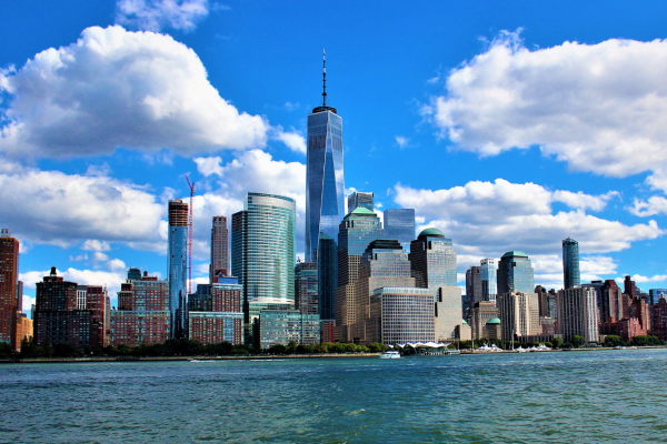 Skyline van New York overdag met wolkenkrabbers en helderblauwe lucht.