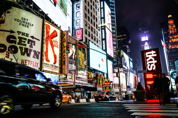 Drukke straten van Times Square gevuld met mensen, neonlichten en reclameborden.