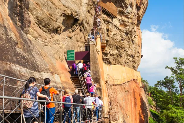Reizigers beklimmen via trappen de rotswand van Sigiriya Rock in Sri Lanka