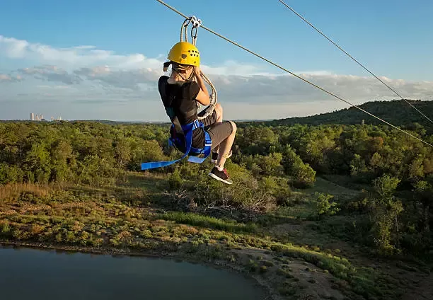 Hazyview_Avontuurlijke reiziger zoeft langs een zipline boven de groene bossen van Hazyview.