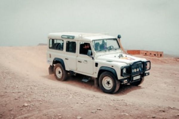 “4x4 safari voertuig in stofspoor bij zonsondergang – safarigevoel in Etosha.”