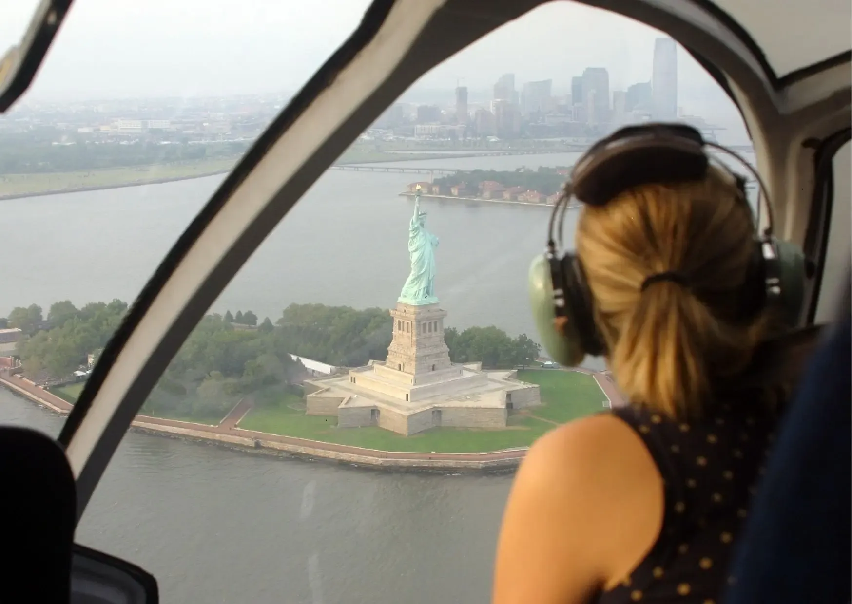 Helikopter vliegt langs de skyline van Manhattan en het Vrijheidsbeeld in New York