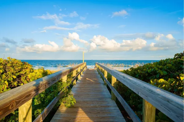 Zandstrand van Cocoa Beach in Florida met palmbomen, zee en blauwe lucht