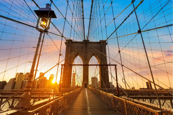 Bezoekers wandelen over de iconische Brooklyn Bridge met uitzicht op de skyline van Manhattan