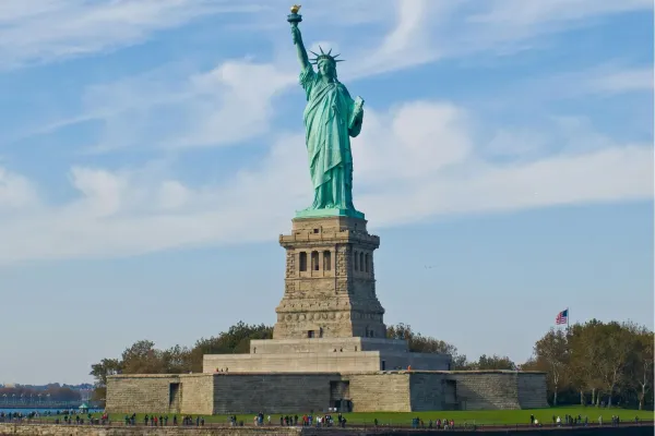 Het Vrijheidsbeeld op Liberty Island in de haven van New York onder een blauwe lucht