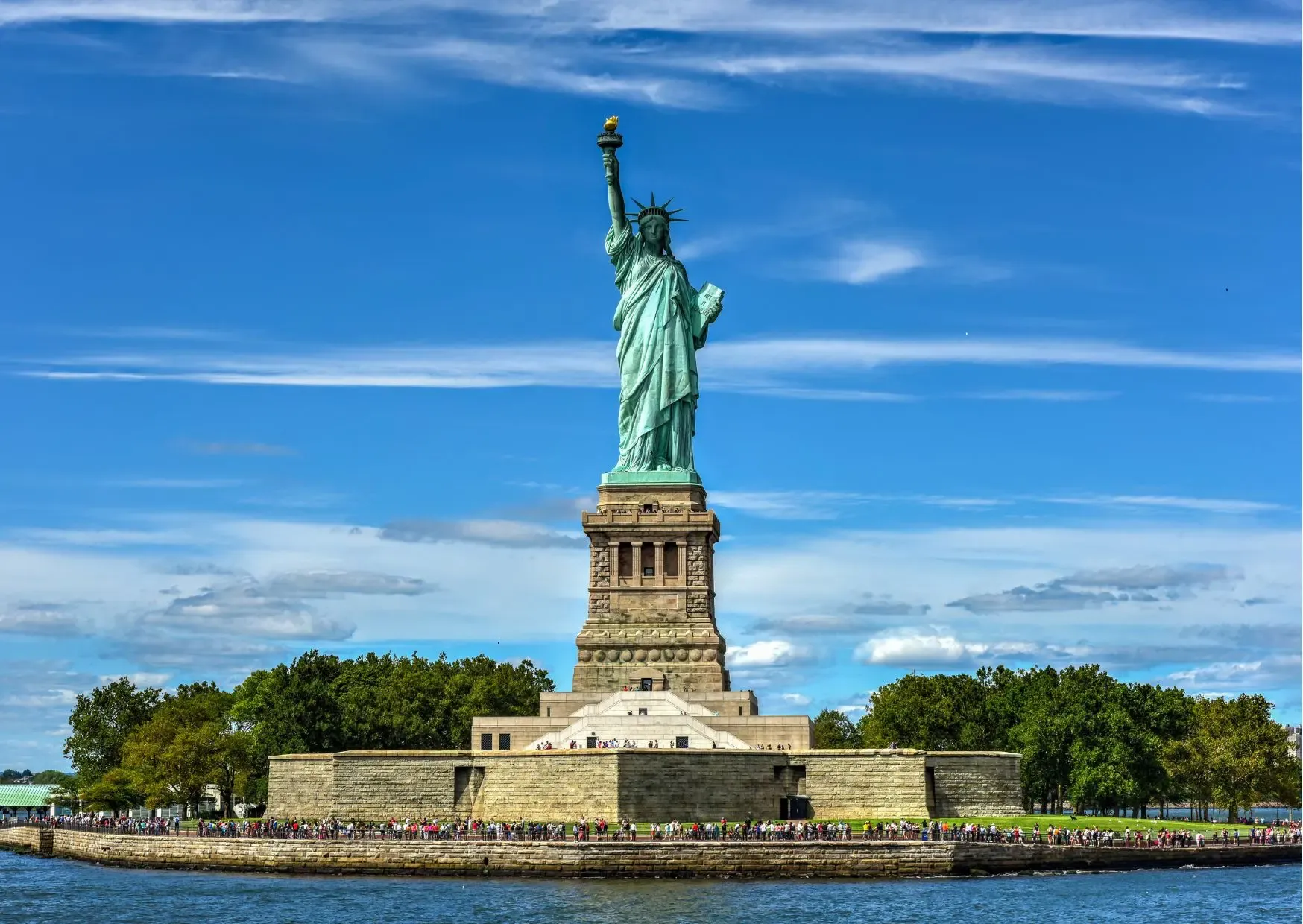 Vrijheidsbeeld in de haven van New York met bezoekers op Liberty Island