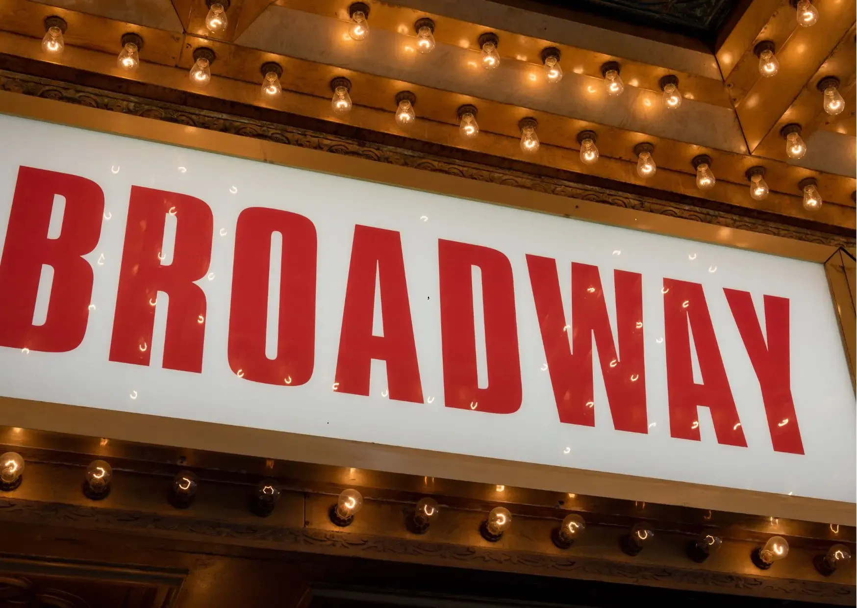 Verlichte theaters en bezoekers in het Broadway Theater District in New York