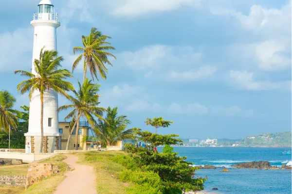 Galle Lighthouse met palmbomen aan de kust bij Galle Fort in Sri Lanka