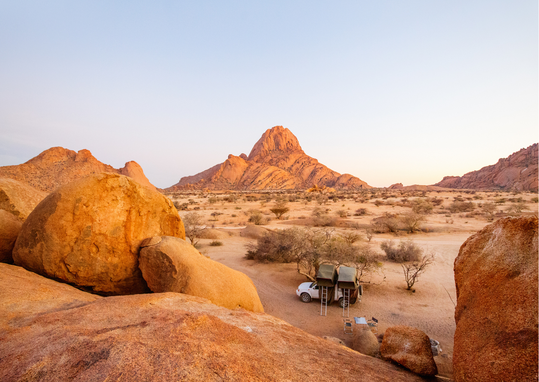 Namutoni_Namibie_Giraffe drinken bij waterhole met zonsondergang