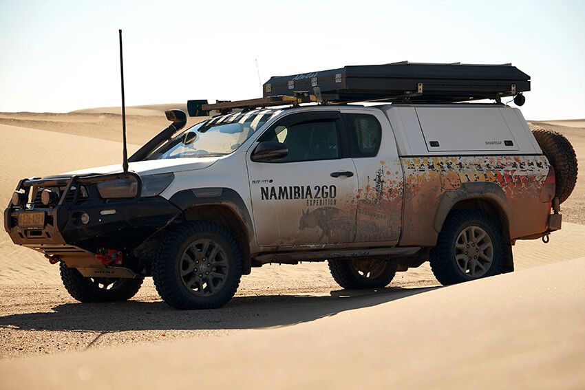 “4x4 Toyota Hilux Expedition Xtra Cab met daktent tijdens selfdrive door het woestijnlandschap van Namibië.”