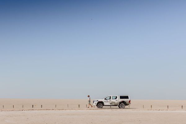 Toyota Hilux Double Cab 4x4 zonder daktent geparkeerd bij safari lodge in Namibië.