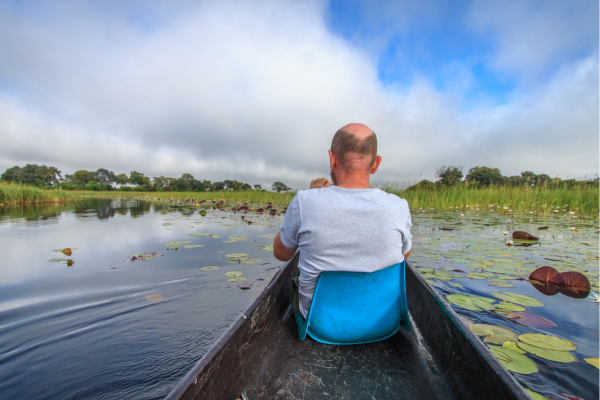 Botswana_Mokoro excursie_Man in boot op de Okavango Delta