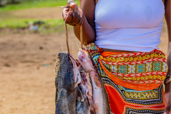 Vrouw met verse vis aan de kust van Namibië