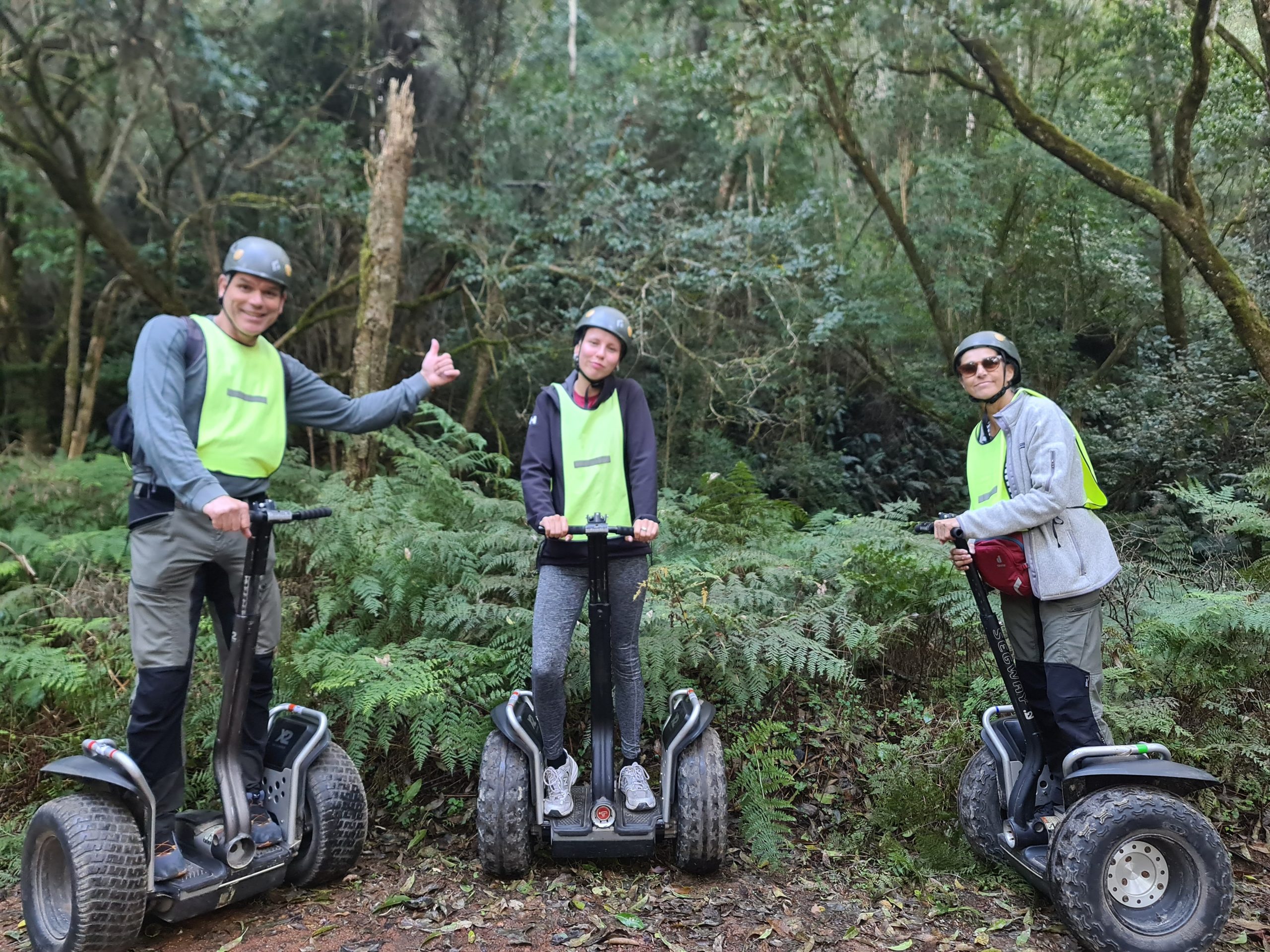 De Tsitsikamma Segway Tour met reizigers die op een segway door het inheemse bos rijden, met bergen en groene vegetatie op de achtergrond.