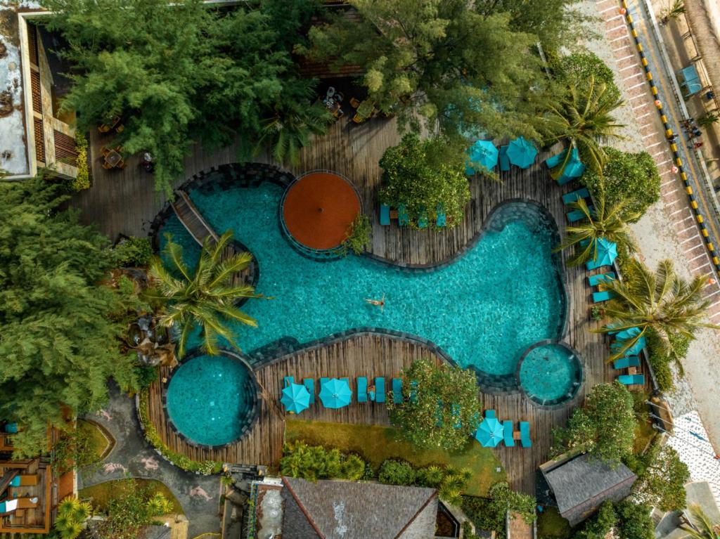 “Tropisch zwembad van Vila Ombak Gili Trawangan omringd door palmbomen.”