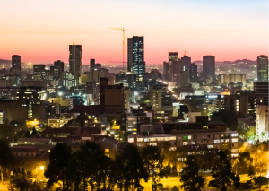 “Uitzicht op Pretoria tijdens golden hour, met de stad badend in zacht avondlicht.”