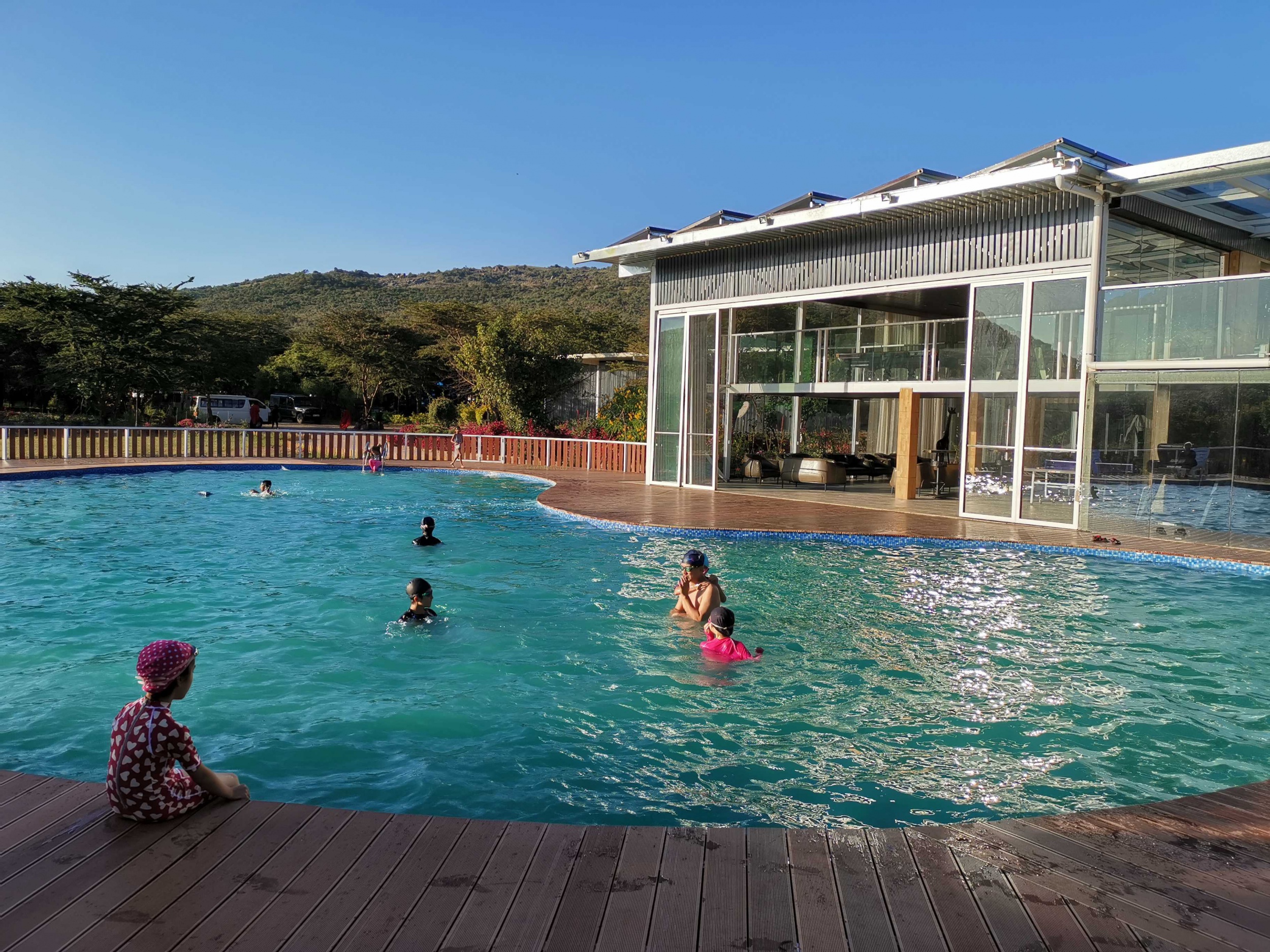 Zwembad van Jambo Mara Safari Lodge met ligbedden en savannezicht